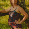 woman wearing red and turquoise swimming costume under tree